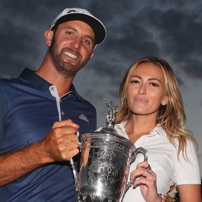 Tristan Gretzky's sister, Paulina Gretzky holding a trophy alongside her husband, Dustin Johnson.